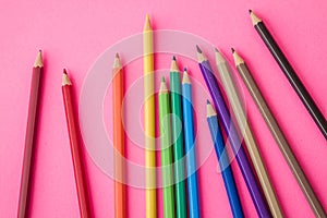 Colorful Pencils Scattered Playfully on a Vibrant Pink Background