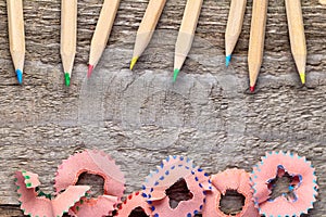 Colorful pencils and sharpen shavings on a wooden table