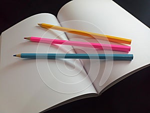 Colorful pencils with a white block note