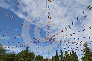 Colorful pennants flags hanging over blue sky. Festival or party concept