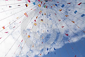 Colorful pennants flags hanging over blue sky. Festival or party concept