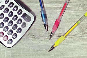 Colorful pens and calculator on the desk.