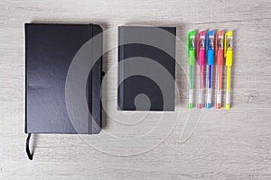 Colorful pens and dark notebooks, financial success.