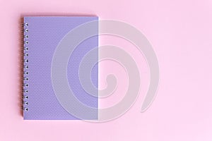 Colorful photography with purple notebook on pink background and free space for text, mock-up. Top view. Learning to draw, making