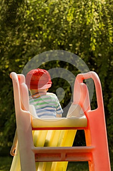 Colorful picture of a boy on a garden slide