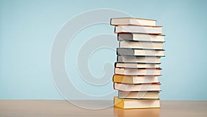 Colorful Pile of Books Against a Pastel Blue Background