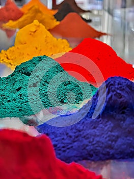 Colorful piles of powdered pigments displayed in a vibrant marketplace in India during the afternoon photo