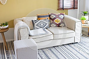 Colorful pillow with native american pattern on sofa in living room.