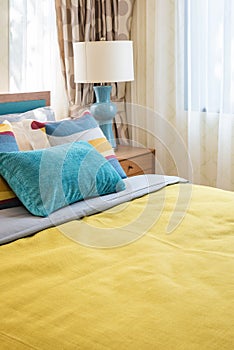 Colorful pillows on wooden bed in modern bedroom design