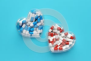 Colorful pills heart shaped close-up on blue background, medical capsules, top view. Valentine\'s day. Dietary supplements.