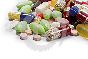 Colorful pills and medical capsules as a corner background isola