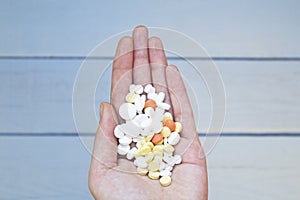 Colorful pills and medicines in the woman hand.