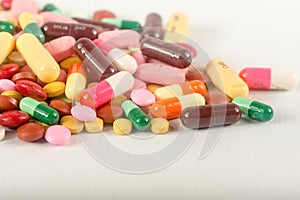 Colorful pills splatter on white background.The different tablets and capsule heap mix therapy drugs