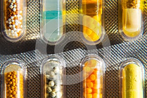 Colorful pills in transparent medicine capsule on white background, illness disease medicine concept