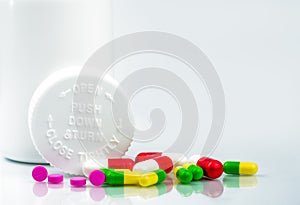 Colorful pills on white background and childproof bottle with blank label and copy space. Pharmacy department in the hospital