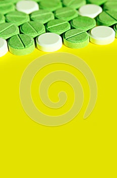 Colorful pills on yellow background, vertical banner.