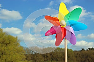 Colorful pin wheel in front of sky and trees