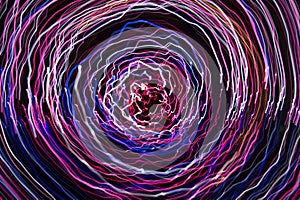 Colorful pink blue neon light trail spiral, black background