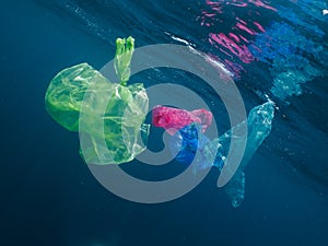 Colorful plastic bags floating in the ocean