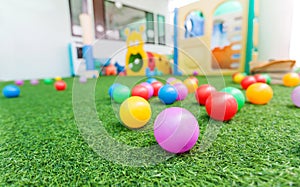 Colorful plastic ball on green turf at school playground