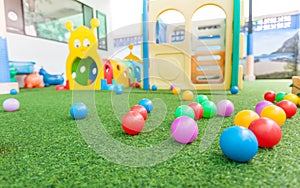 Colorful plastic ball on green turf at school playground