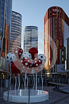 Colorful plastic balloon symbols and office buildings photo
