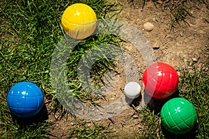 Colorful plastic boules or boccia balls are lying on a green meadow photo