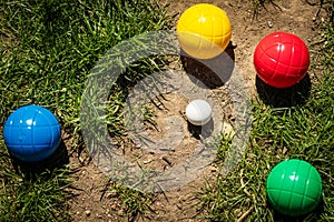 Colorful plastic boules or boccia balls are lying on a green meadow photo