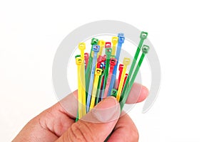 Colorful plastic cable ties in hand isolated
