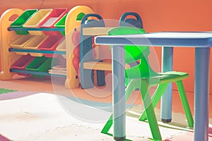 Colorful plastic chair and desk for children playing and learning in kids room in vintage style.