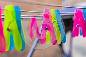 Colorful plastic clothes pegs on empty metal clothes dryer