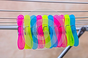 Colorful plastic clothes pegs on empty metal clothes dryer