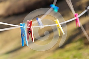 Colorful plastic clothes pegs on white clothesline, fashion business concept