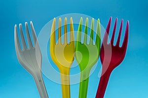 Colorful plastic forks on blue background