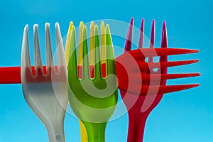 Colorful plastic forks on blue background