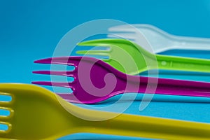 Colorful plastic forks on blue background