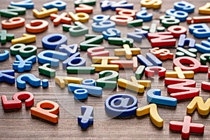 Colorful plastic letters and numbers on wooden background