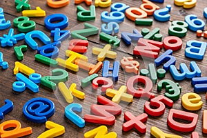 Colorful plastic letters and numbers on wooden background