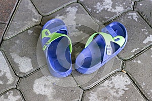Colorful plastic man slippers on concrete floor