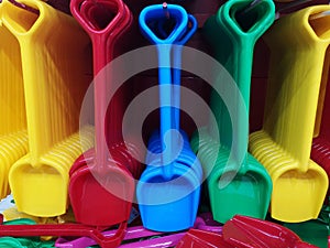 Colorful plastic shovels toys in shop. Colored shovels in the market