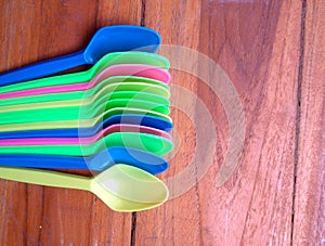 colorful plastic spoon on wood table.