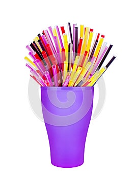 Colorful plastic straws in cup white background isolated close up, disposable drinking pipes in glass, tubes for beverage cocktail