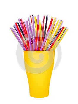 Colorful plastic straws in cup white background isolated close up, disposable drinking pipes in glass, tubes for beverage cocktail