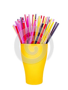 Colorful plastic straws in cup white background isolated close up, disposable drinking pipes in glass, tubes for beverage cocktail