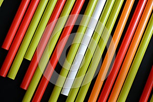 Colorful plastic straws on a dark background