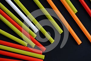 Colorful plastic straws on a dark background