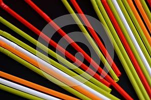 Colorful plastic straws on a dark background