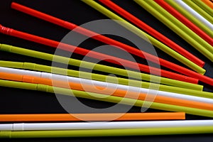 Colorful plastic straws on a dark background