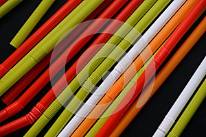 Colorful plastic straws on a dark background