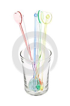 Colorful plastic swizzle sticks in glass